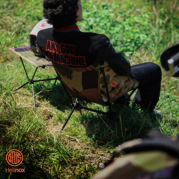 man sitting in a portable camp chair on the grass