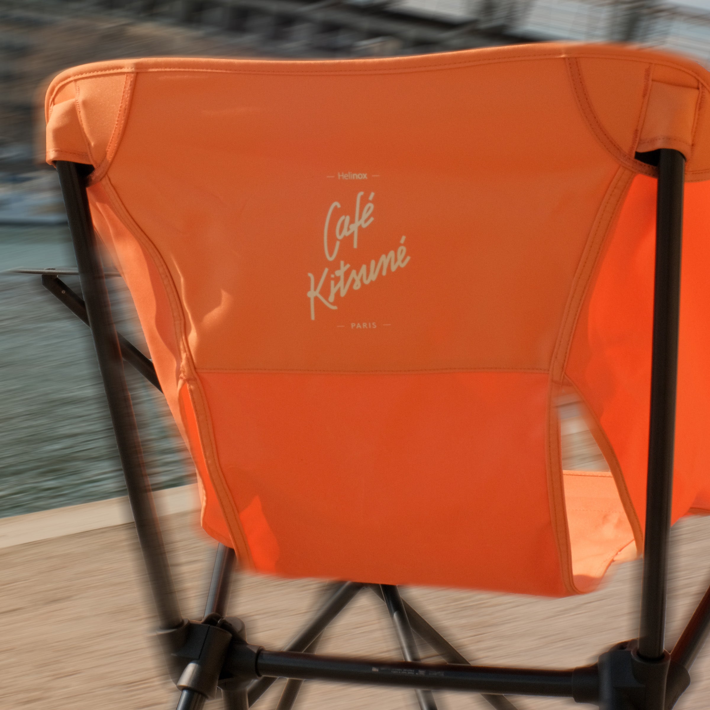 Back view of an orange Helinox x Café Kitsuné camp chair