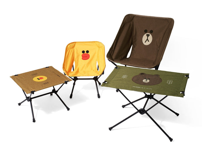 Helinox camping set featuring Brown bear and Sally duck character chairs and folding side tables on a white background