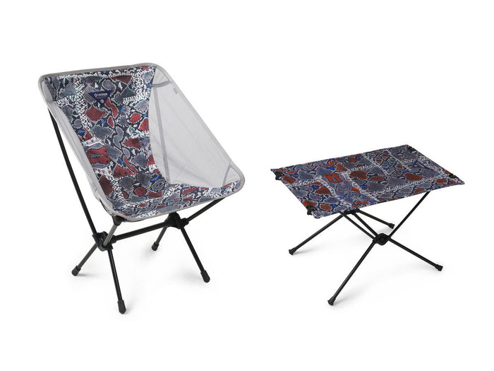 Helinox camp chair and table set in a colorful snakeskin pattern on a white background