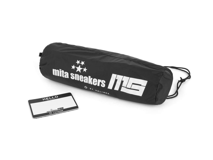Black Helinox x mita sneakers storage bag and logo tag on a white background