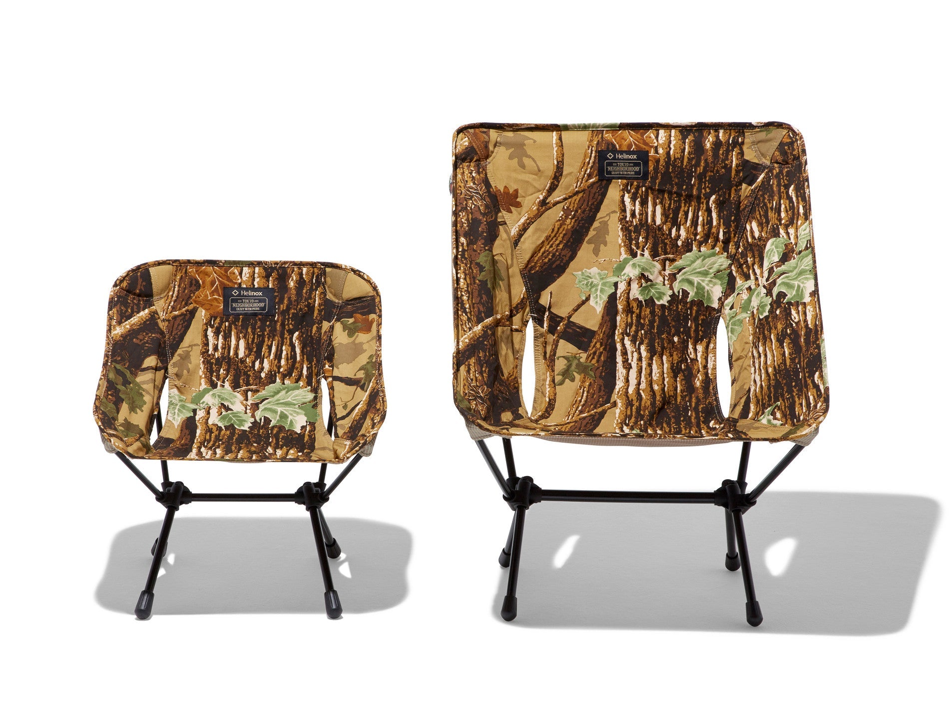 Two Helinox camp chairs in tree bark camouflage print side by side for size comparison
