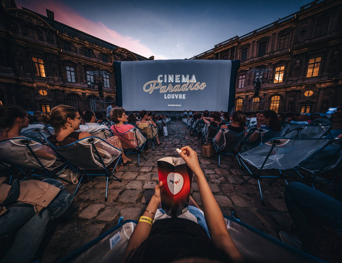 Audience seated in Helinox camp chairs at the Cinema Paradiso Louvre outdoor movie screening