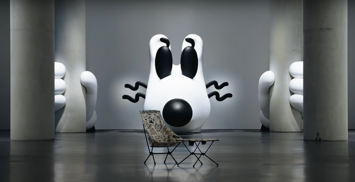 Camp chair and table in front of steven harrington installation 