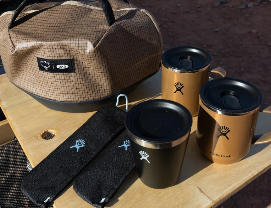 Hydro Flask mugs and Osprey bag on a Helinox table